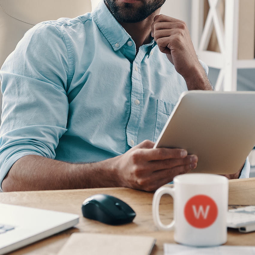 cropped man working at desk laptop tablet wpromote mug